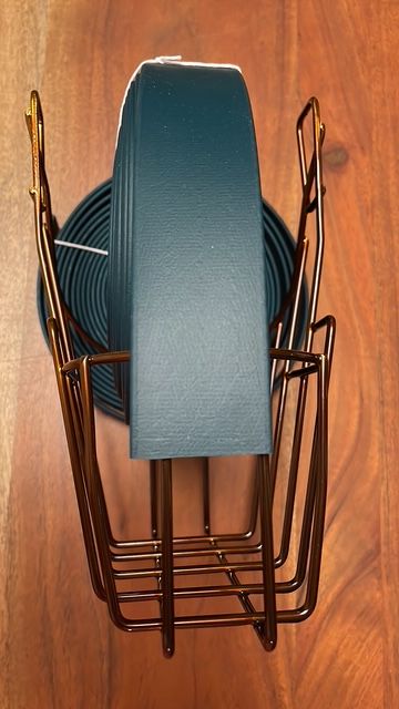 Blauer Kopfhörer in einem metallenen Halter auf einem Holztablett.