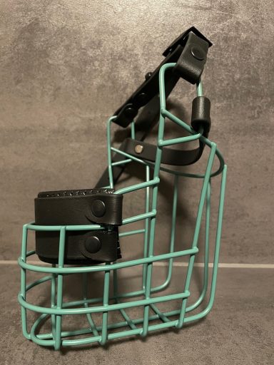 Metallischer Gitterkorb in Türkis mit schwarzem Halter. Ideal für kleine Gegenstände.