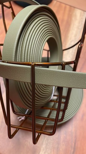 Ein grauer, spiralförmiger Schlauch in einem metallenen Halter.